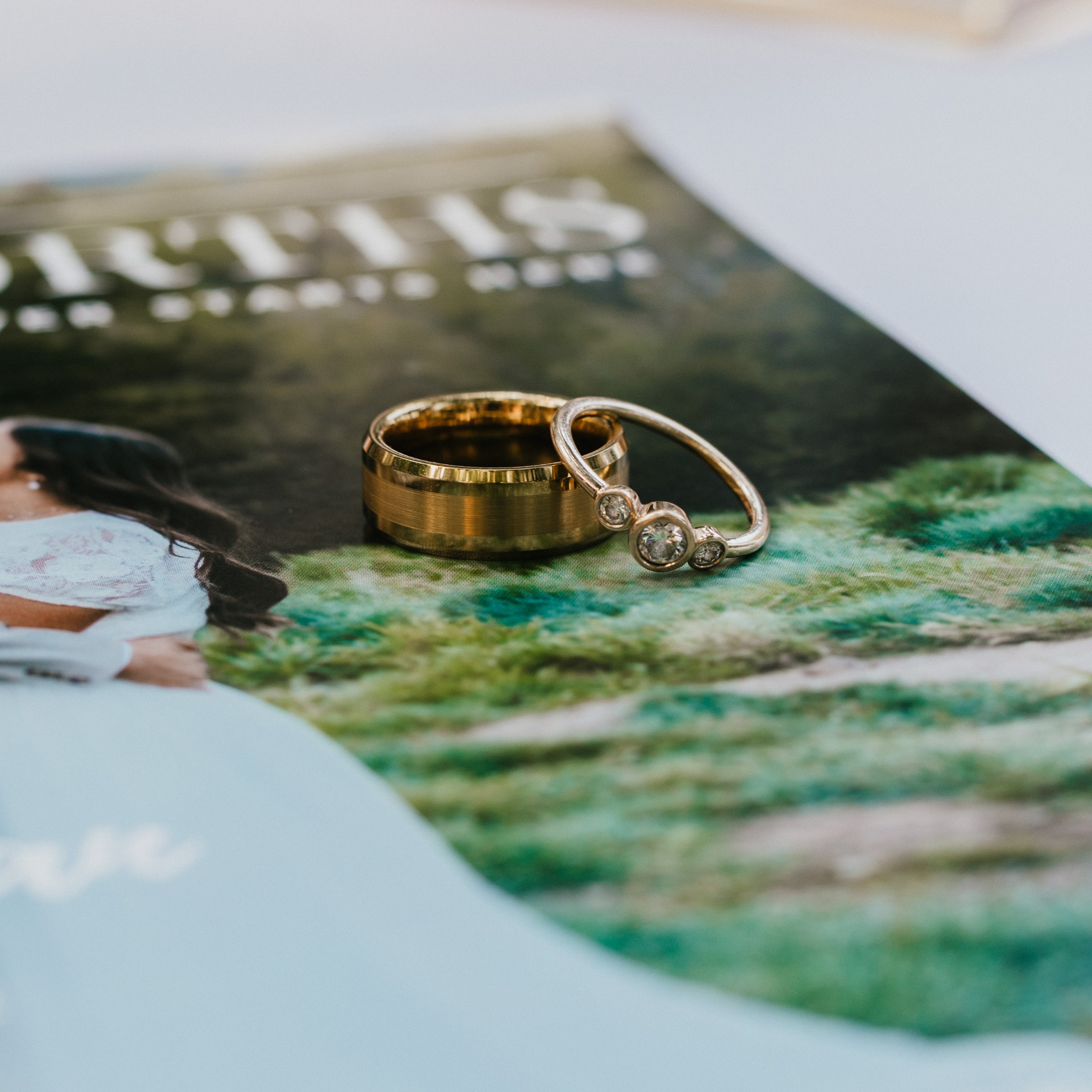 Maria and Ryan's wedding rings resting on their custom wedding magazine